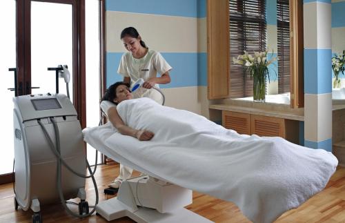 a woman in a hospital room with a patient in a bed at The Chateau Spa & Wellness Resort in Bukit Tinggi