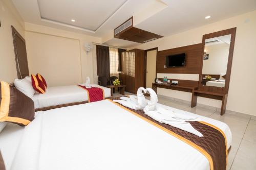 a hotel room with two beds and a mirror at KK Comforts in Shrīrangapattana