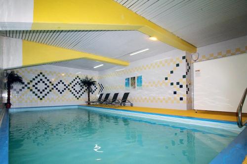 a swimming pool in a room with chairs and a bed at Apartman Mitterdorf in Philippsreut