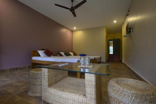 een kamer met een bed en een tafel en stoelen bij Villa de hollong in Mādāri Hāt