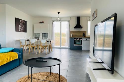 uma sala de estar com um sofá azul e uma mesa em Spacious modern house near the Golf of Ardrée em Saint-Antoine-du-Rocher