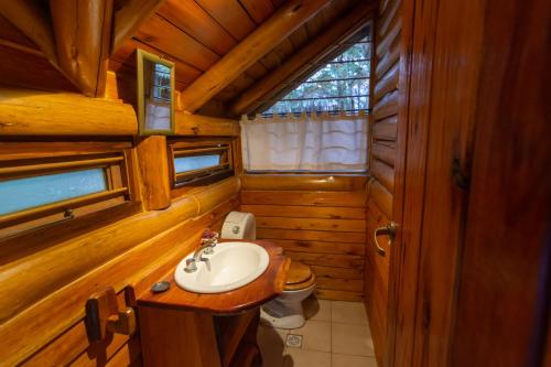 a bathroom with a sink and a toilet in a cabin at Cabañas Cumelen in Villa Gesell