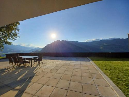 a table and chairs on a patio with a view of a mountain at Panorama Alpendorf in Sankt Johann im Pongau