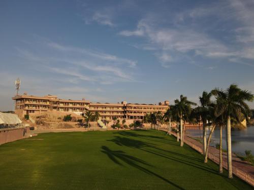 a large building with palm trees in front of it at Lake View Hotel and Resort in Jodhpur