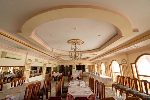 a dining room with tables and chairs and a chandelier at Lake View Hotel and Resort in Jodhpur