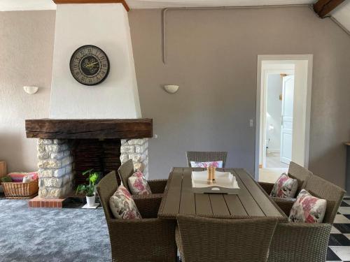 un salon avec une table et une cheminée dans l'établissement Lac De Lumiere. Relax with rural lakeside living, à Herry