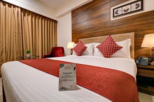 a hotel room with a bed with a sign on it at Hotel Tip Top International Pune in Pune