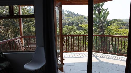 a room with a view of a balcony with a chair at Nkutu River Lodge in Kloof