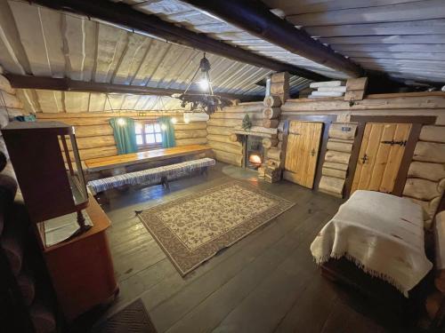 a large room with a bed in a log cabin at Forest hut Stariy Prud in Filippovichi