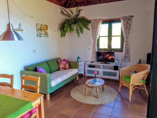 een woonkamer met een bank en een tafel bij Casa Flor azul in Las Tricias