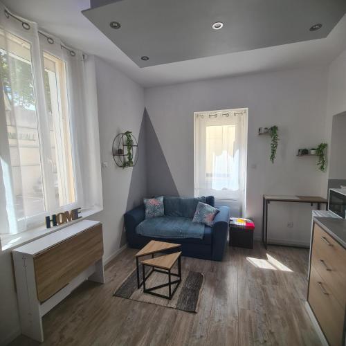 un salon avec un canapé bleu et une table dans l'établissement Très joli appartement 2 pièces, centre-ville, à Tuchan