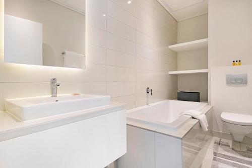 Baño blanco con lavabo y aseo en Stay In Luxury at Stonehill Place, en Ciudad del Cabo