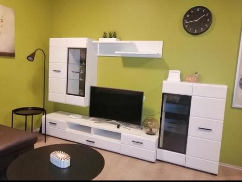 uma sala de estar com um centro de entretenimento branco com uma televisão em Apartman Sara em Umag