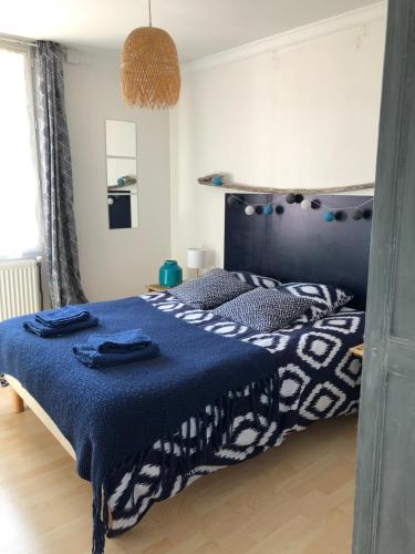 - une chambre avec un lit et une couette bleue dans l'établissement La courtine Etretat maison de pêcheur 2 mn de la mer, à Étretat