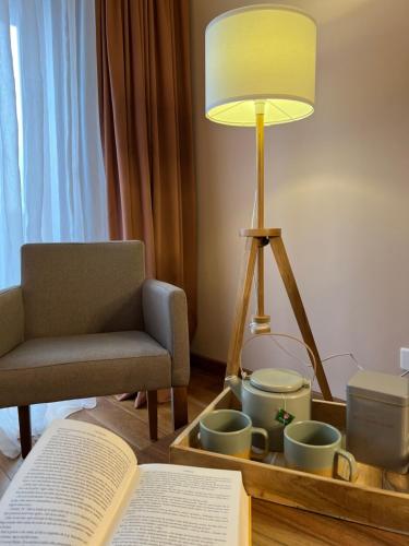 a living room with a chair and a lamp and a book at Apartman B328-Aparthotel Vučko Jahorina in Jahorina
