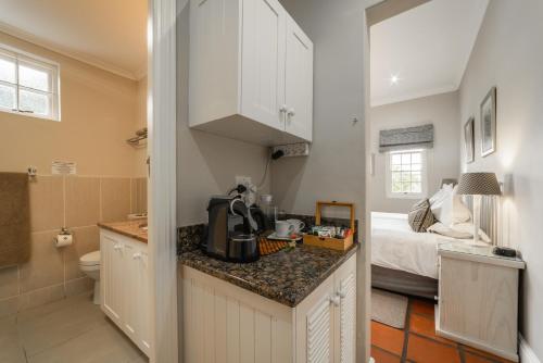 cocina con fregadero y baño con cama en Eikendal Lodge, en Stellenbosch