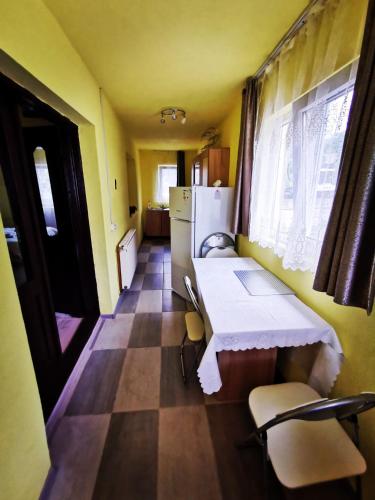 a small kitchen with a table and a refrigerator at Casa Rusu in Mălăeşti
