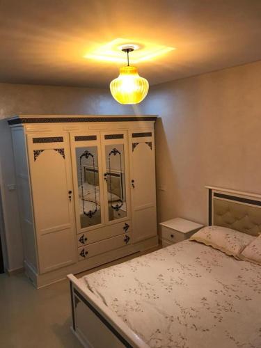 a bedroom with a bed and a chandelier at اقامة السعادة in Nador