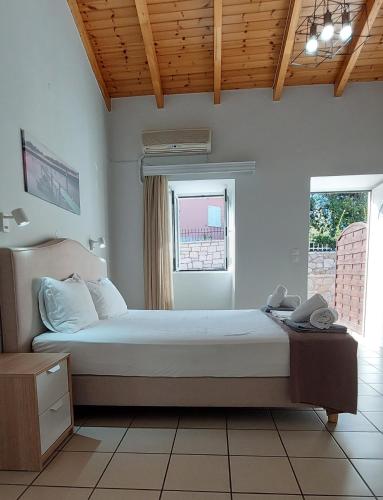 a bedroom with a bed and a window at Electra Villa & Pool Studios in Gaios