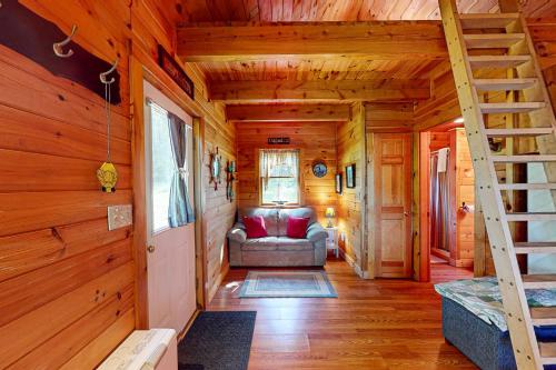 a living room with a staircase in a log cabin at Lenas' Lakeside Cabin in Waterville