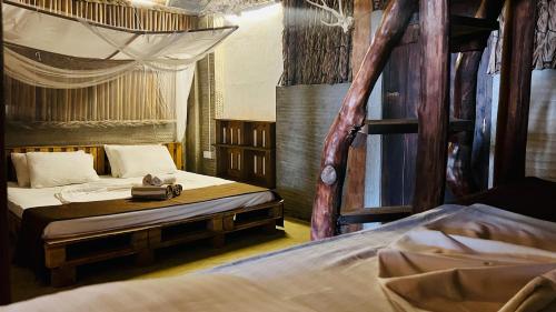 a bedroom with two beds and a canopy bed at Wind Blend Kite Resort in Kalpitiya