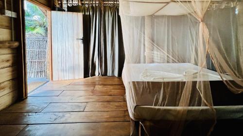a bedroom with a bed with a mosquito net at Wind Blend Kite Resort in Kalpitiya