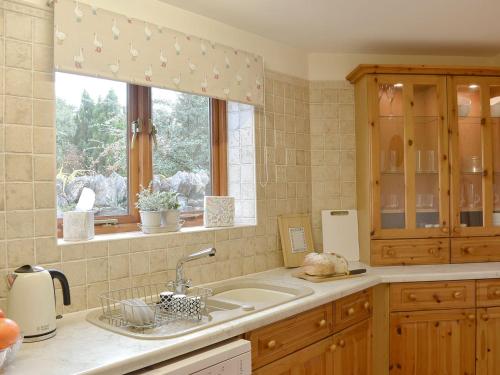 una cucina con lavandino e finestra di Bluebell Barn a Ravenstonedale