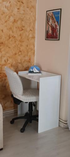 a white desk with a chair next to a wall at Eftihia di corfu in Corfu Town