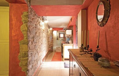 una cocina con paredes rojas y una pared de piedra. en Casa in pietra con accesso privato al fiume, en San Clemente in Valle