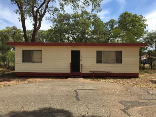 a small white house with a red roof at Wagon Wheel Motel & Units in Coonabarabran