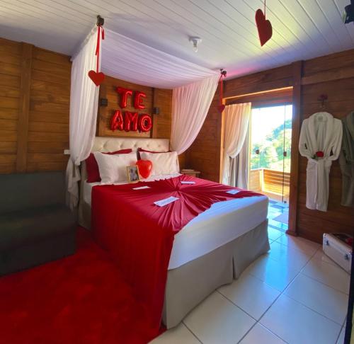 a bedroom with a bed with a red canopy at Cabana Amor Perfeito in Barracão