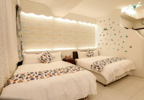 a bedroom with two beds and a window with butterflies on the wall at Lucky Star Homestay in Jian