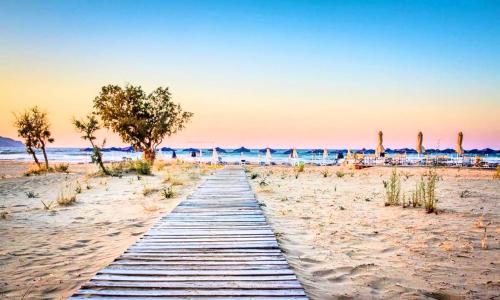 a wooden pathway through the sand on a beach at Stavento Luxury Villa Private Pool in Georgioupolis