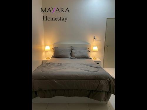 a bedroom with a bed with two lamps on it at MAYARA Homestay @ Residensi Lili in Nilai