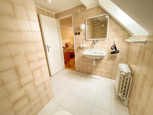 uma casa de banho com um lavatório e um espelho em Ubytování Kubantovi em Praga