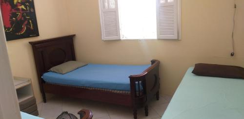 ein kleines Schlafzimmer mit einem Bett und einem Fenster in der Unterkunft A Bela Casa da Ilha, na Ilha de Vera Cruz, Coroa, 300m da praia! in Salvador