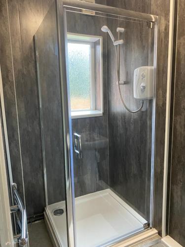 a shower with a glass door and a window at Montrose - Perfect contractor stay, own driveway, 3 bedrooms in Gateshead