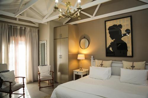 a bedroom with a white bed and a chandelier at 5 Konings Guesthouse in Paarl