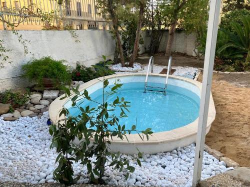 a small swimming pool in a garden with rocks at Il Gelso nella Valle in Agrigento