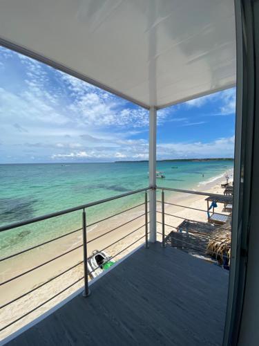 una vista sulla spiaggia dal balcone di una casa sulla spiaggia di Villas Encanto a Barú