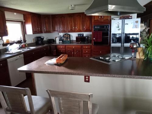 a kitchen with wooden cabinets and a counter top at 2,000 ft home on the St Lawrence, incredible views Canada, hot tub in Ogdensburg