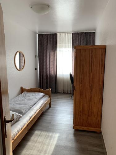 a bedroom with a bed and a wooden door at City Hotel Dinslaken in Dinslaken