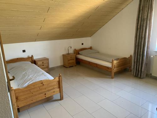 a bedroom with two beds and a ceiling at City Hotel Dinslaken in Dinslaken