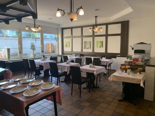 a restaurant with tables and chairs with plates on them at City Hotel Dinslaken in Dinslaken