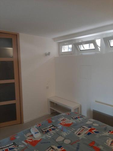 une chambre avec un lit et deux fenêtres dans l'établissement Appartement climatisé au calme en Provence, à Pierrefeu-du-Var