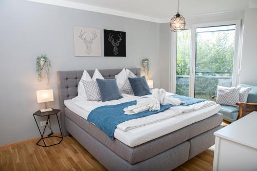 ein Schlafzimmer mit einem großen Bett mit einer blauen Decke in der Unterkunft Customflats - Tiefgarage - Terrasse - Uninähe in Ulm