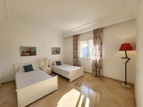 a living room with two beds and a window at Le Bleu Céleste in Hammamet