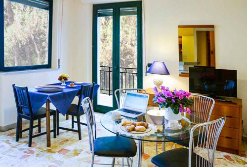 a dining room with a table and a laptop on it at Villa delle Palme in Acitrezza