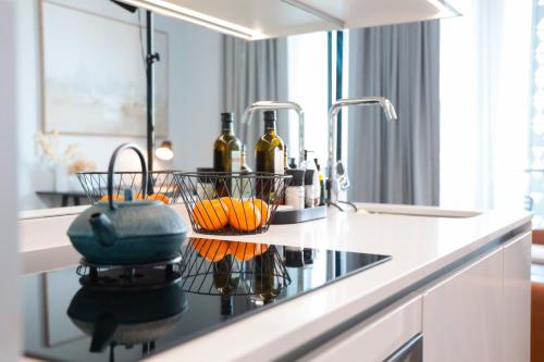 a kitchen counter with two sinks and bottles of wine at Luxury Apartment at Ellipse Waterfall, Midrand Near Mall of Africa in Midrand