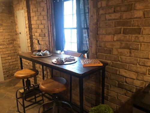 a table in a room with a brick wall at Savannah Sojourn - Time Travelers Retreat 1853 in Savannah
